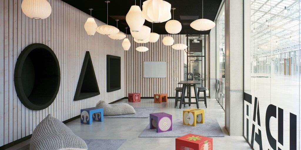 Moderne speelruimte met kleurrijke kindermeubels en bijzondere wandelementen.