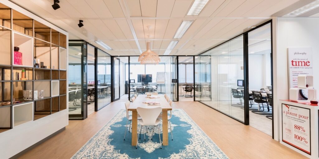 Moderne vergaderruimte in kantoor met glazen wanden en blauw tapijt.