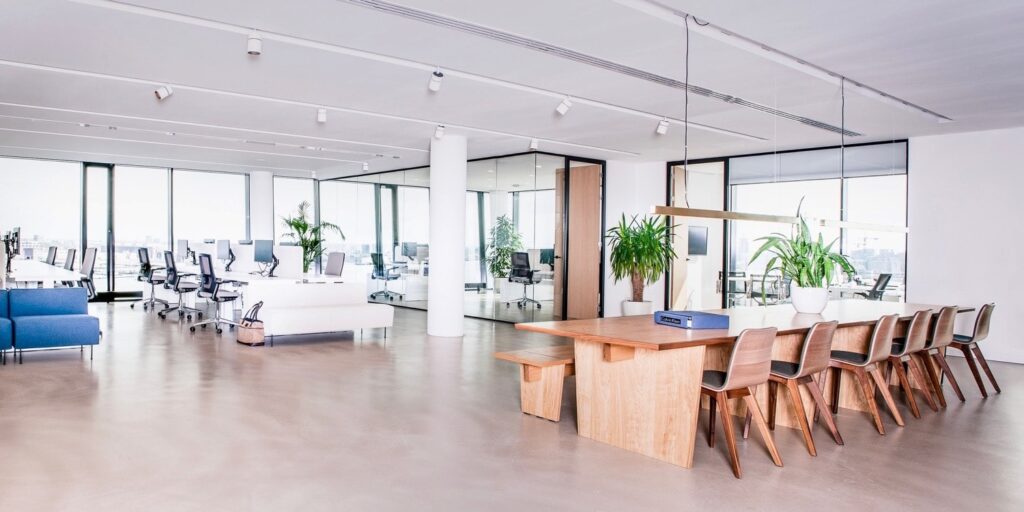Moderne kantoorruimte met grote bureaus en veel natuurlijk licht.