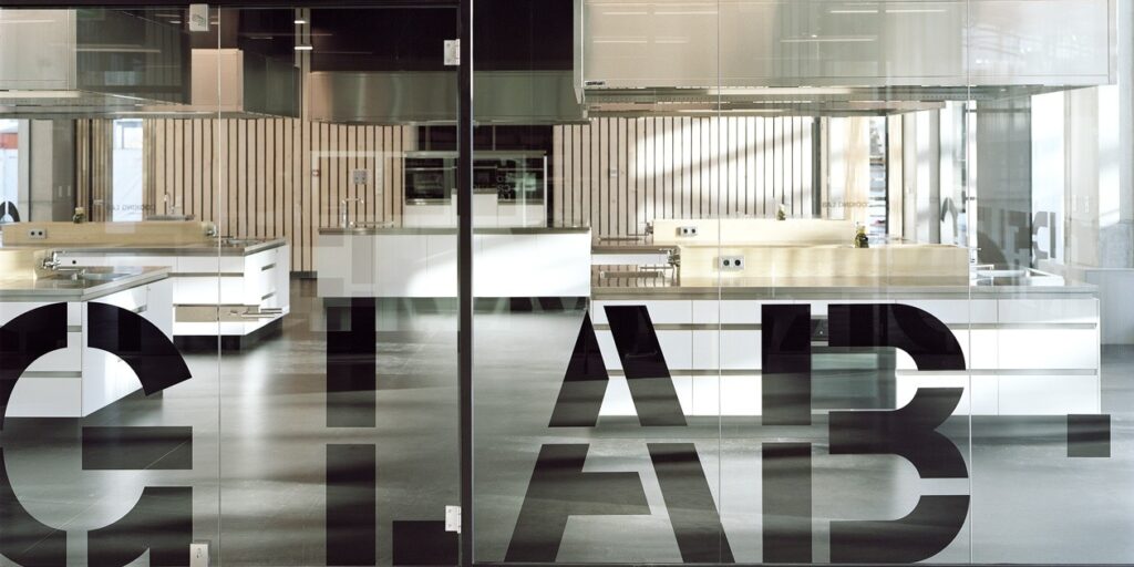 Kookstudio achter glas met de tekst 'Lab'. Modern design.