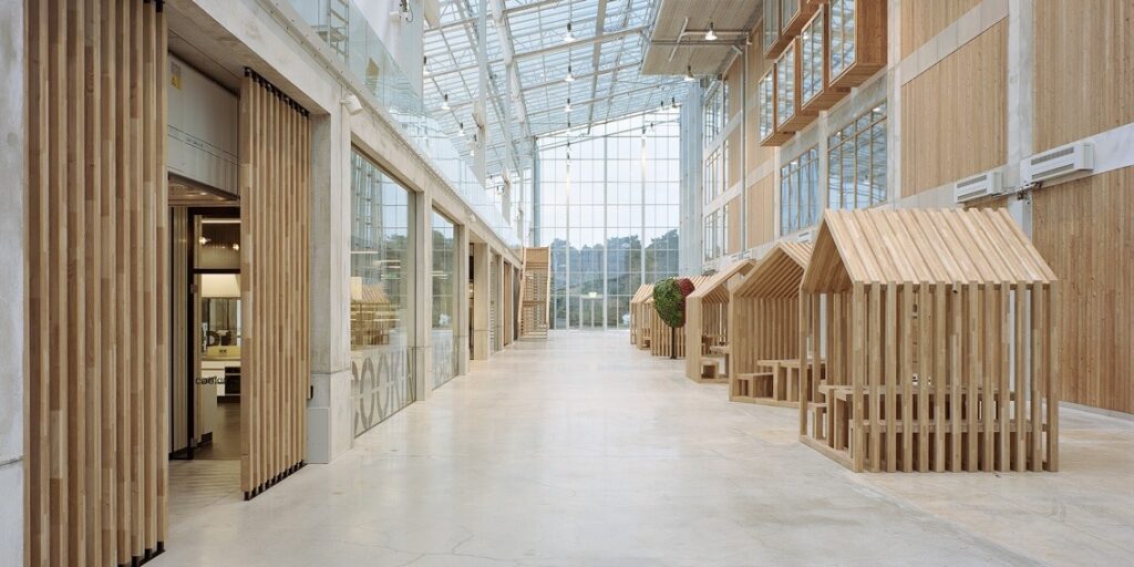 Houten hutten in een modern gebouw met glazen dak.