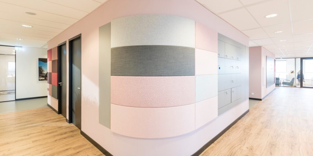 Kantoor interieur met roze accenten en wanddecoratie. Opbergkasten in de gang.