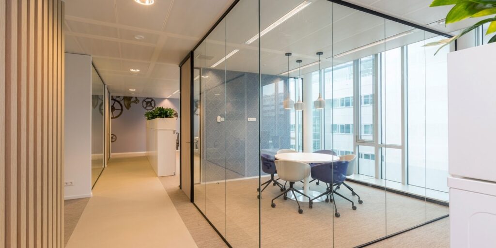 Vergaderruimte met glazen wanden in een modern kantoor.
