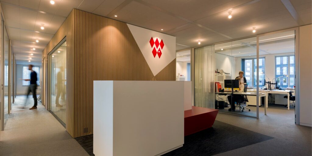 Moderne kantoorreceptie met houten wand en logo.