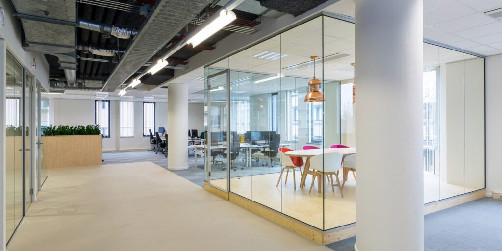 Modern kantoor met glazen vergaderruimte en design meubilair.