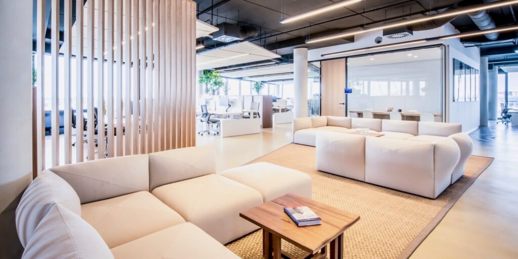 Moderne kantoorlounge met witte banken en houten details