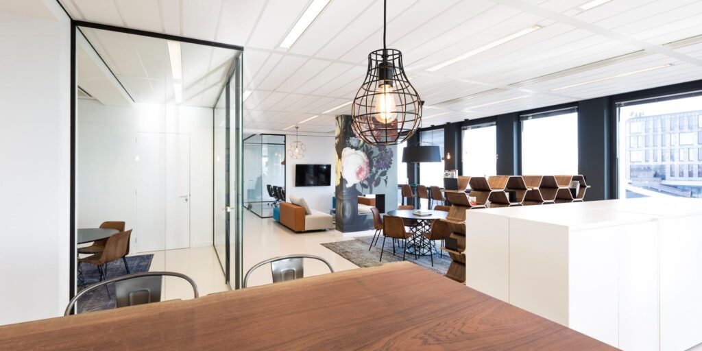 Moderne kantoor open ruimte met overlegplekken en glazen wanden.