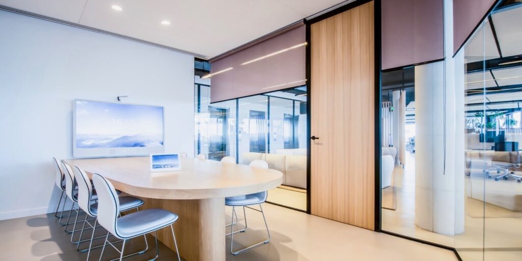 Moderne vergaderruimte met ovale tafel en smart tv in een kantoor.