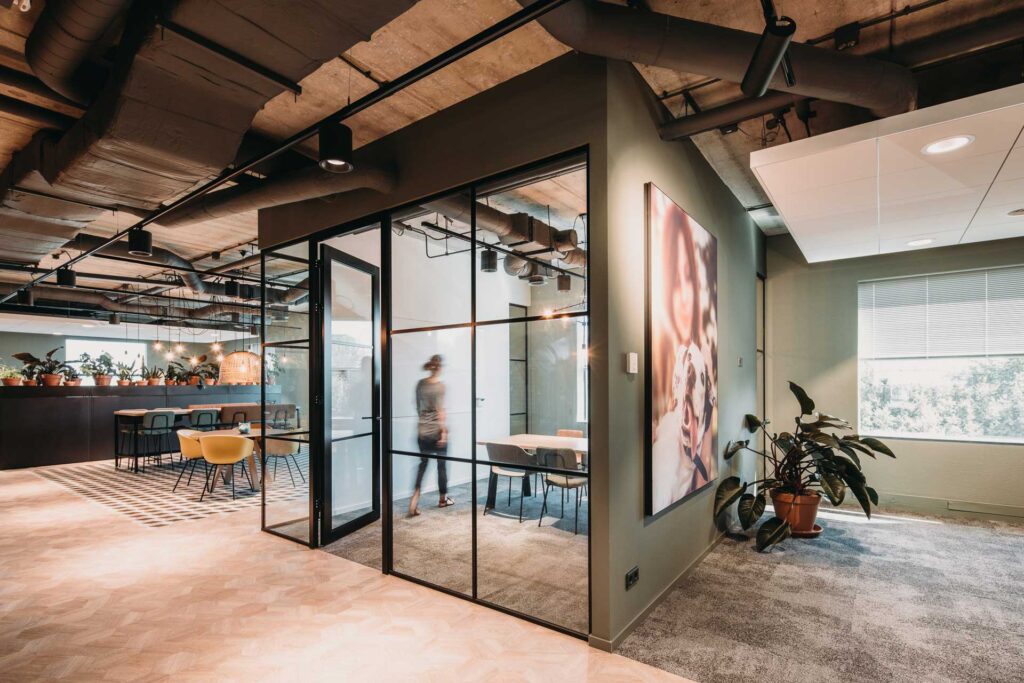 Modern kantoorinterieur met glazen wand en vergaderruimte.