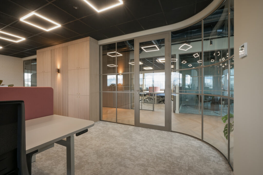 Moderne vergaderruimte met glazen wand en kantoormeubilair.