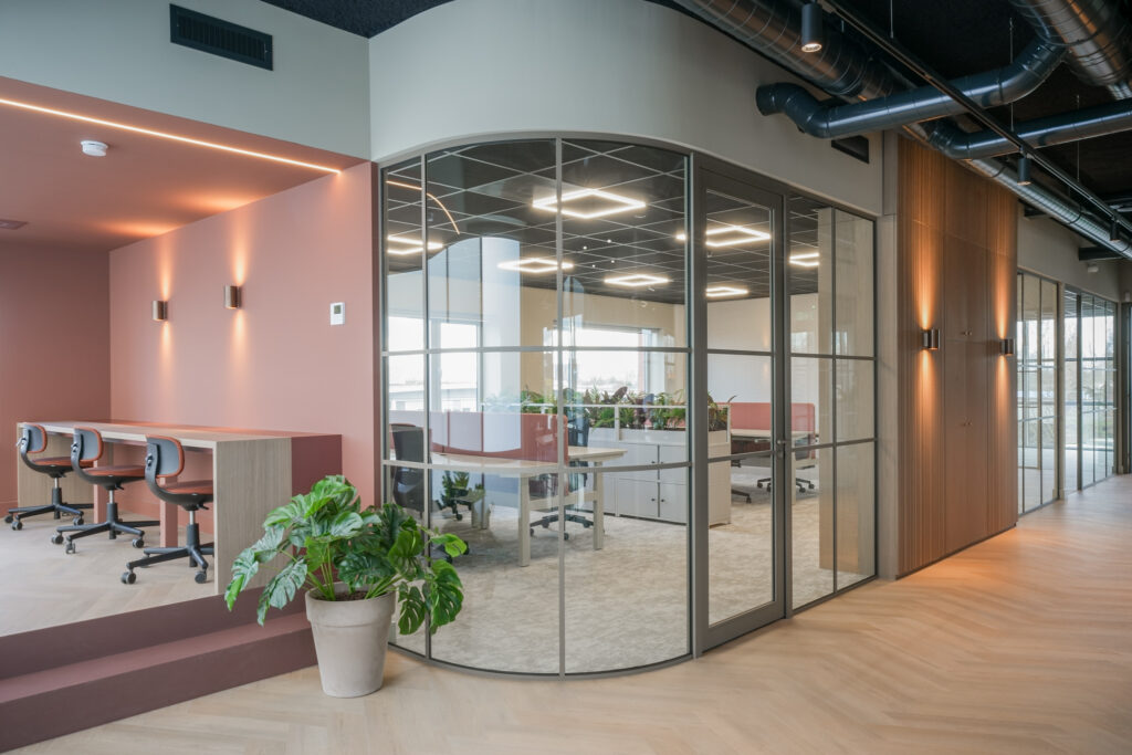 Modern kantoorinterieur met bureaus en glazen wanden.