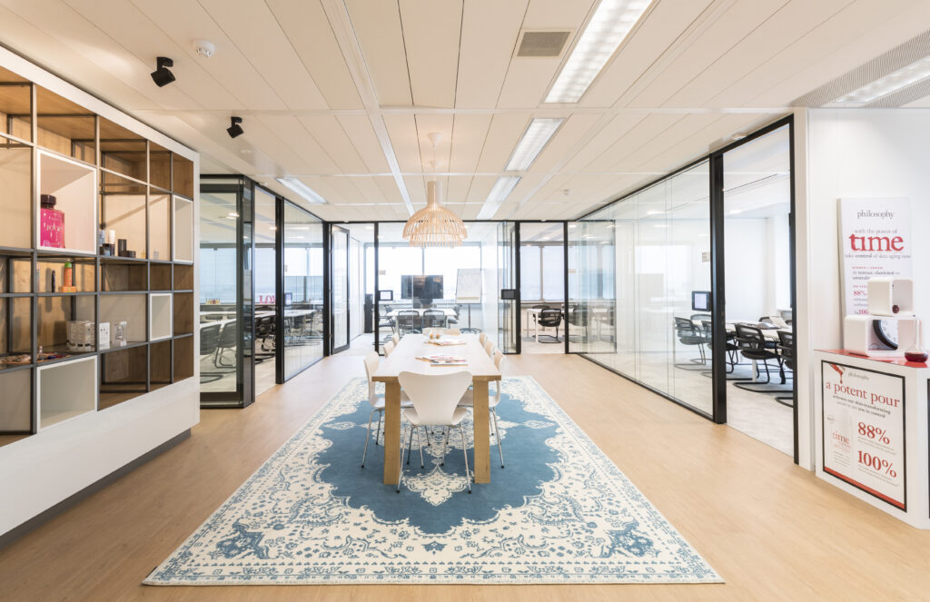 Moderne vergaderruimte met lange tafel en blauw tapijt in een kantoor.