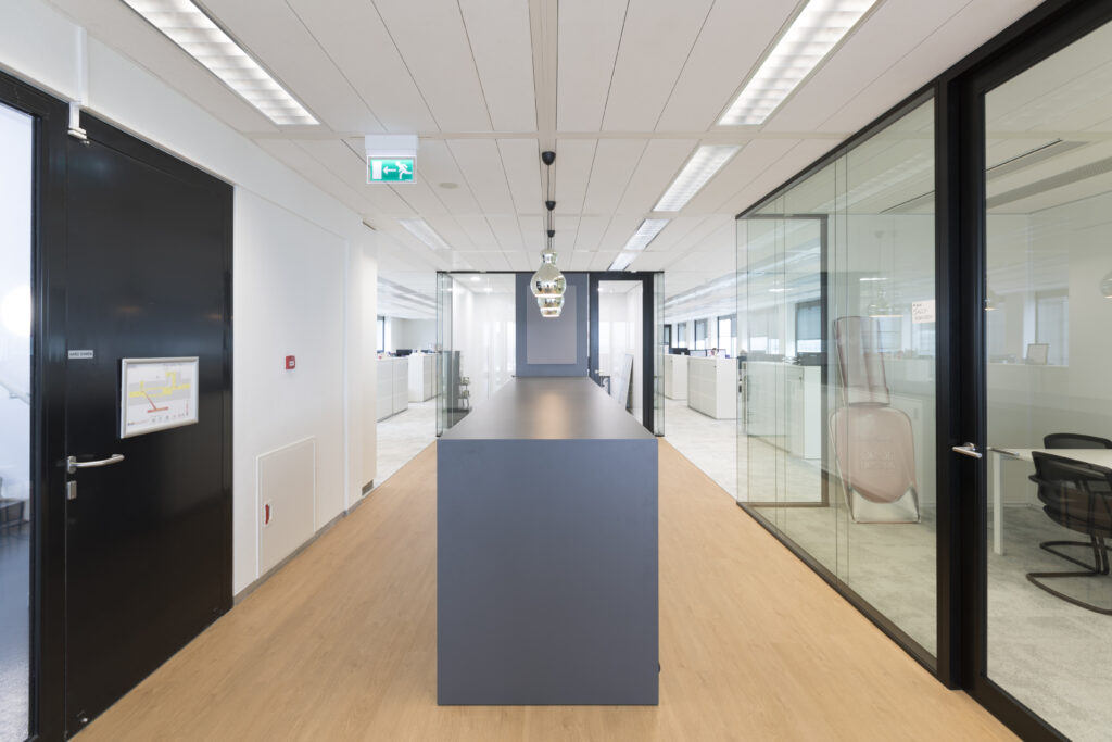 Glazen kantoorruimte met moderne werkplekken en kasten. 