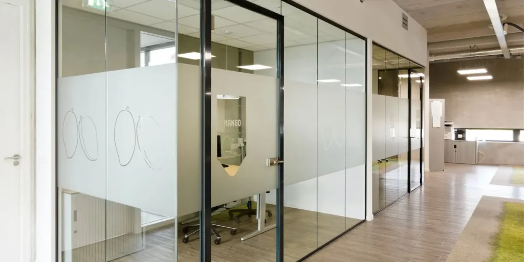 Glazen scheidingswanden in modern kantoor met decoratief glasfolie.