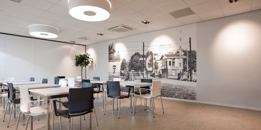 Kantineruimte met tafels en stoelen in een modern interieur.