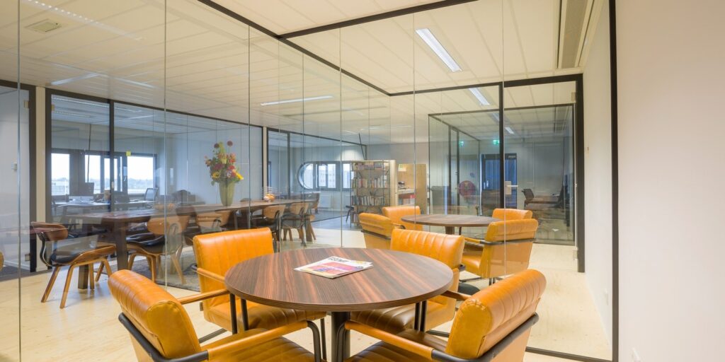 Vergaderruimte met lederen stoelen in een modern kantoor.