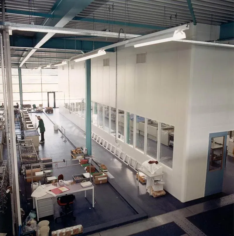 Interieur van een fabriek met een medewerker bezig met productie.