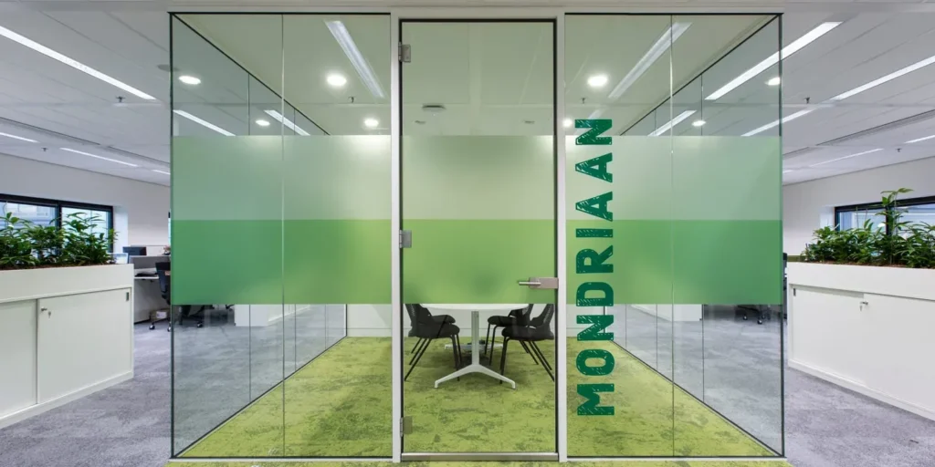 Vergaderruimte met glazen wand en de naam 'Mondriaan' erop gedrukt.