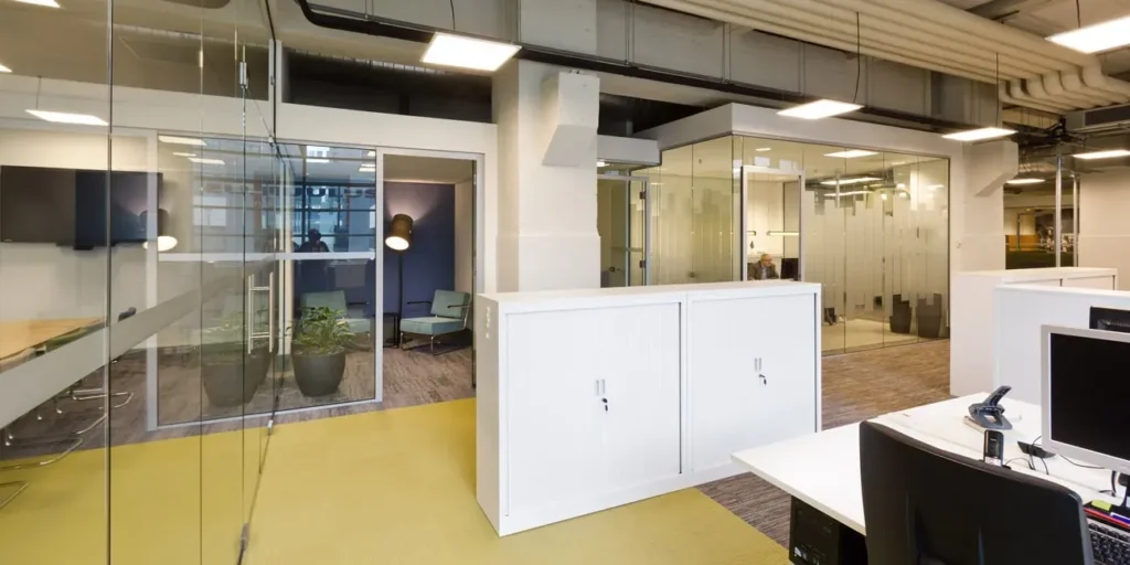 Modern kantoorinterieur met glazen wanden en open werkplekken.