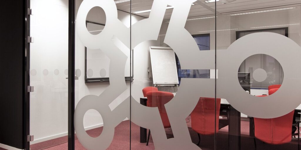 Vergaderruimte met glazen wand en abstract ontwerp voor privacy.