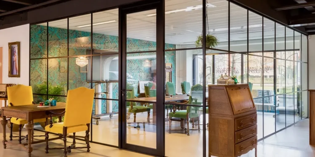 Interieur met glazen wand die een vergaderruimte scheidt van de rest van het kantoor.