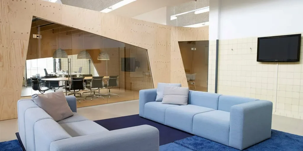 Vergaderruimte met blauwe banken en glazen wand voor een moderne uitstraling.