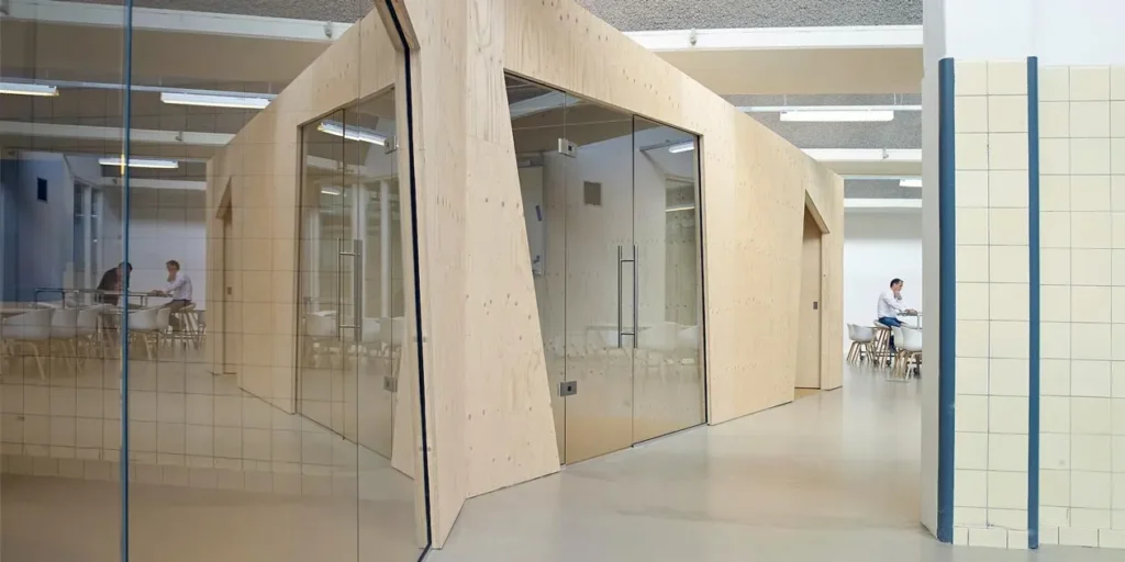 Houten kantoor ontwerp met glazen wanden en mensen in vergadering.