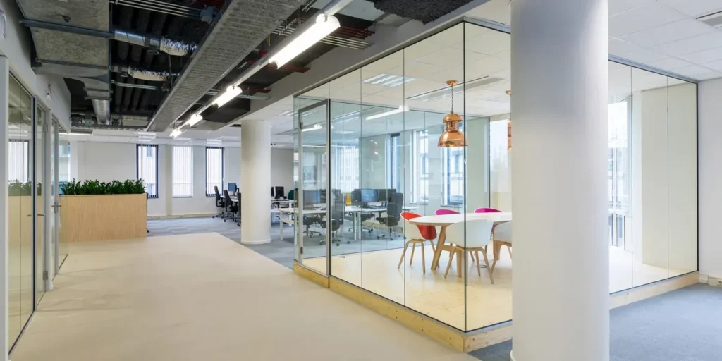Modern kantoor met glazen wanden en vergaderruimte.