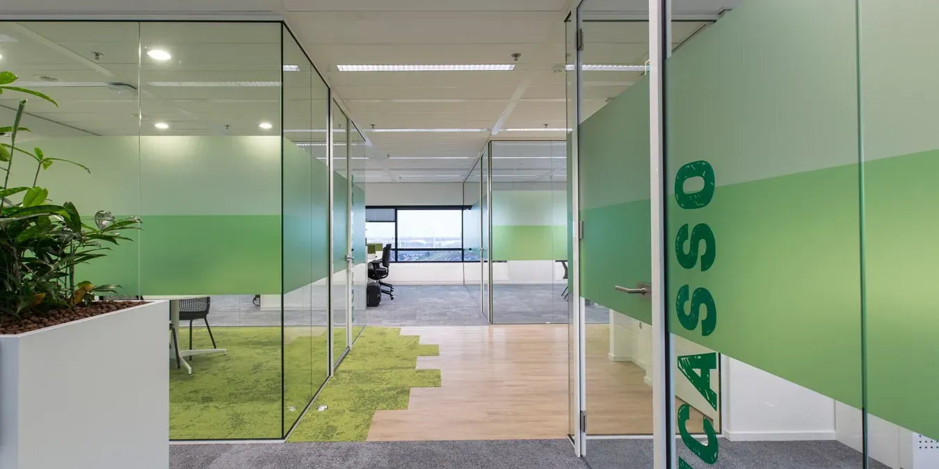 Modern kantoor met glazen wanden en groen accent