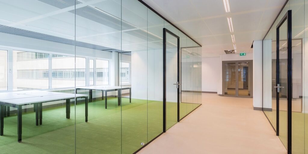 Modern kantoor met glazen wanden en vergaderruimte.