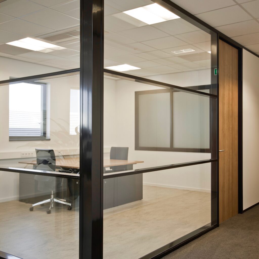 Moderne vergaderruimte achter een glazen wand in een kantoor.